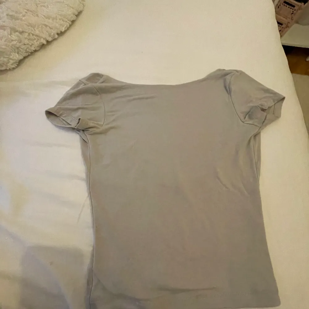 Säljer min supersnygga T-shirt med öppen rygg! Köpt från missäy men står it storlek🩷Är som en xs! Är grå beige och har inga defekter!. T-shirts.