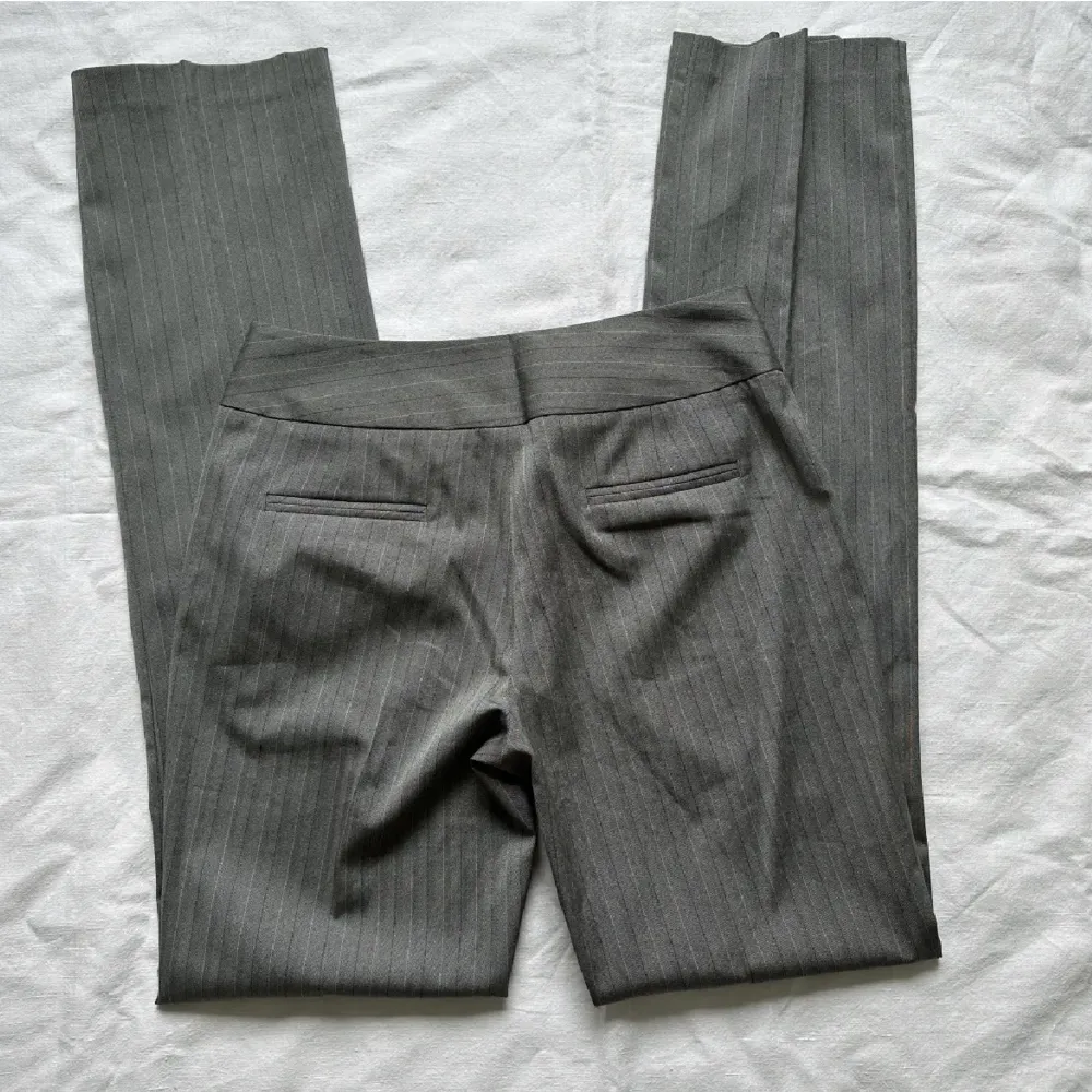 Ett par gråa lågmidjade kostymbyxor. Väldigt långa i benen och nyskick.. Jeans & Byxor.