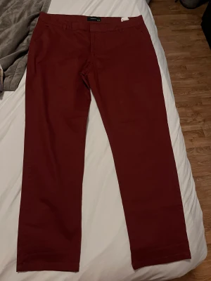 Vinröda chinos - Säljer vidare ett par vinröda chinos som inte passade. Köptes för 75 kronor. Jättefina. Låg/normal. 