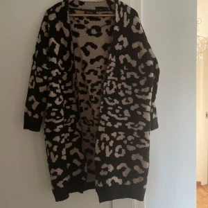 Kofta - Lång kofta i stickat material. Går lite under knäna jag är ca 170 cm lång. Säljer pågrund av att den inte längre kommer till användning 