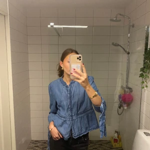 Blus i denim - Jeansblus med en liten volang och snörning på ärmen. Den har inga defekter🥰