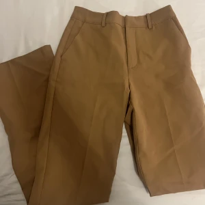 Kostymbyxor - Beige/bruna bootcut kostymbyxor från bikbok.