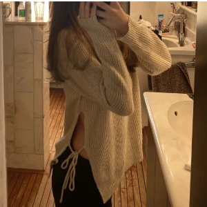 Beige stickad med slits  - Beige stickad tröja med en liten slits. Skick 10/10, skriv för frågor och bilder