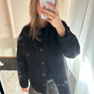 Svart kort kappa - En svart kort kappa med knappar! Knappt använd! 