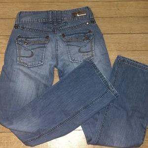 Lågmidjade jeans  - Ett par jätte snygga lågmidjade bootcut jeans som är köpta i london💗 byxorna är i jätte bra skick(ser helt nya ut) och har coola detaljer på fickorna🙌 Pris går såklart att diskutera💋