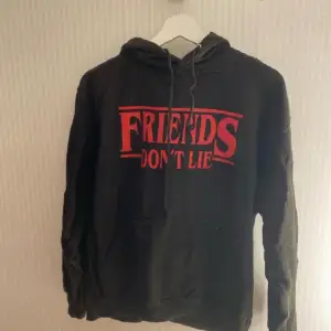 Hoodie med rött tryck där det står ”friends don’t lie” på framsidan. Den köptes för flera år sedan men har inte används särskilt mycket så är fortfarande i bra skick!! Skulle nog säga att den är liten i storlek, snarare en S