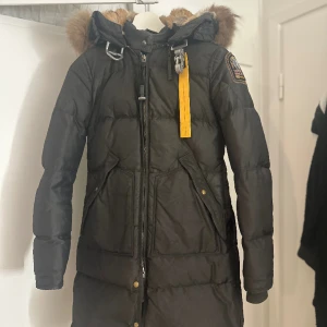 Parajumpers, long bear  - Lång dunjacka från parajumpers, färgen är en blandning av svart grön och grå (skiftar färg), två framfickor, stort löstagbart spänne i halsen och äkta päls på och i luvan. Kvitto finns ej kvar, mer bilder kan skickas på jackan privat. 
