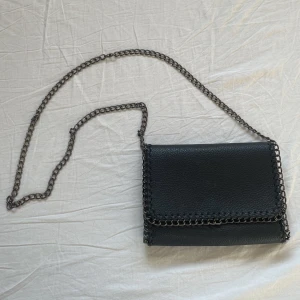 Väska  - Aldrig använd av mig. Ganska rymlig, får plats med nycklar, telefon, plånbok etc. Kan ha små tecken på användning på kedjan men inget man märker alls.Använd gärna köp nu men skriv gärna till mig först.