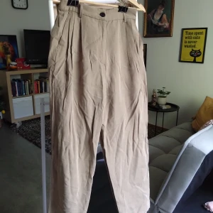 Breezy beige pleated pants. - Beige plisserade byxor i mjukt material. Knappt använda och säljes i mycket bra skick.
