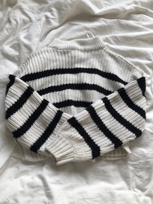Stickad tröja - En jätte fin stickad tröja som är randig vit och svart. Säljer pågrund av den är för liten för mig.
