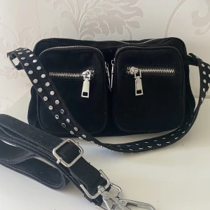 Svart Noella väska  - Säljer nu min suuupersnygga Noella väska då den tyvärr inte kommer till användning. Använd max 3 gånger så den är i väldigt fint skick. Mått: höjd 15cm, bredd 25cm, djup 7cm. En avtagbar och justerbar axelrem medföljer! 🩷⭐️