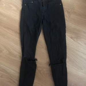 Svarta skinny jeans med hål på knäna 