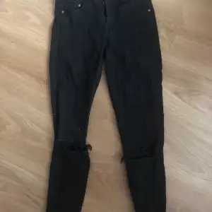 Svarta skinny jeans med hål på knäna 