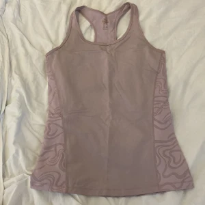 linne - Träningslinne, mycket mer rosa/lila i verkligheten. Brottar rygg. Passar XS-M med mindre bröst. Köparen står för frakten.