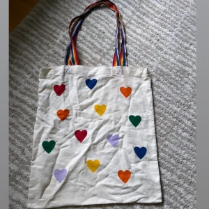 Påsväska med Pride färger  - En super söt liten påsväska med Pride färger, från Monki. 