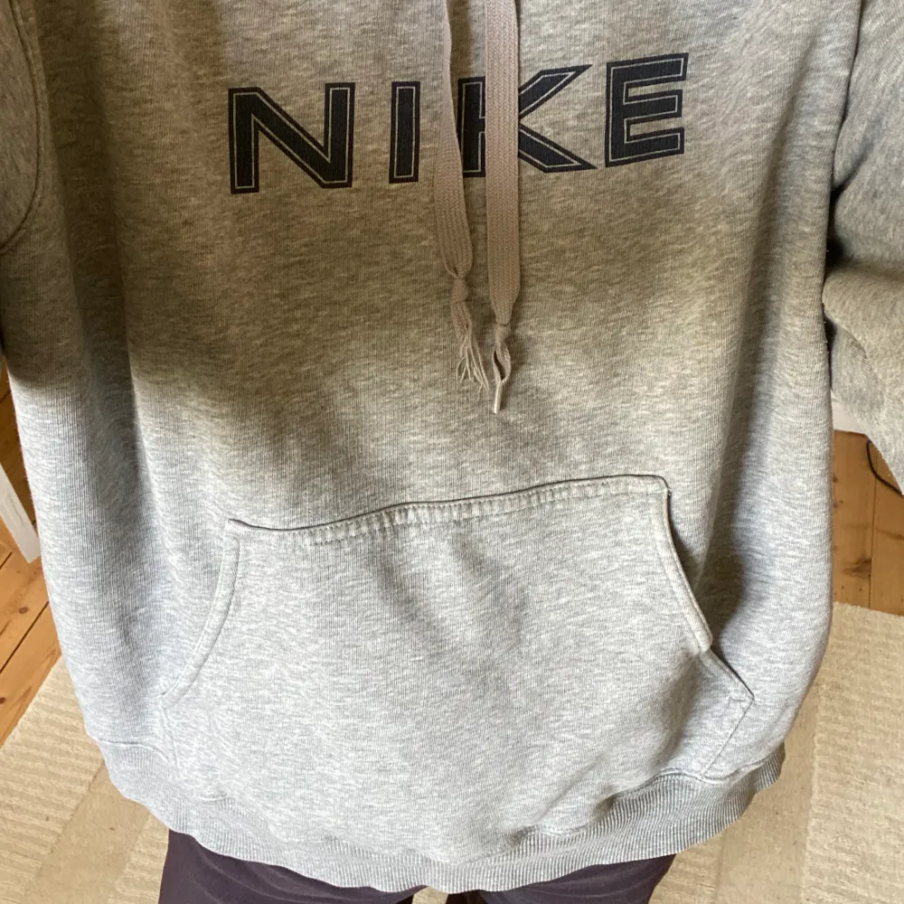 Jättecool grå Nike hoodie med mörkblå detaljer. Ena snöret i luvan är lite slitet men annars har den inga defekter!. Hoodies.