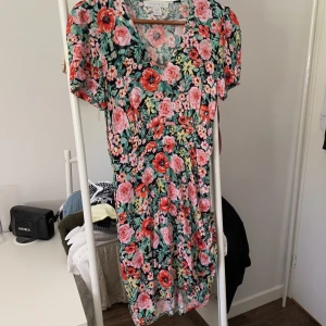 Sommarklänning - Blommig sommarklänning från NewYorker. Inte använd så mycket. Finns en dragkedja i midjan och sitter fint på kroppen. 