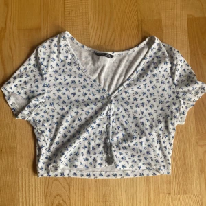 Blommig topp - Vit kort topp med blåa blommor. Från shein.