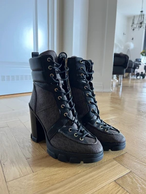 Michael Kors boots med hög klack & snörning - Äkta Michael kors boots med cirka 9cm klack & 2cm platå. Snörning fram och guldig dragkedja på sidan. Köpta för 1300kr på rea för cirka 1,5 år sedan och endast använda 1 gång. I princip som nyskick.