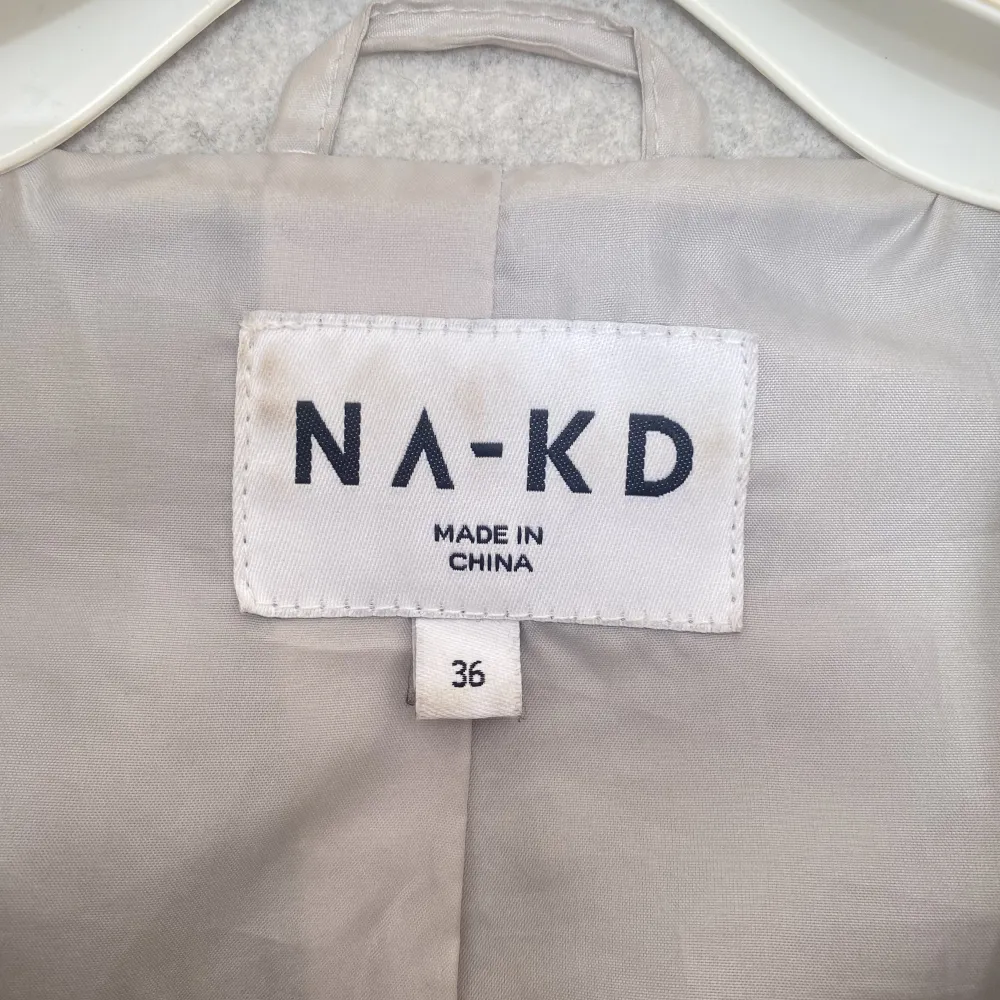 Populär kort grå kappa från NA-KD i storlek S. Använd mycket men inga tydliga tecken på slitage. . Jackor.