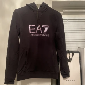 EA7 tröja - Säljer denna EA7 hoodien🤍Svart med lila metall tryck