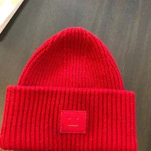 Röd Acne Studios mössa  - Säljer nu min superfina acne mössa då den inte längre kommer till användning! Inga defekter och sparsamt använd. Köparen står för fraktkostnad! Pris kan diskuteras vid snabb affär, Kram!❤️