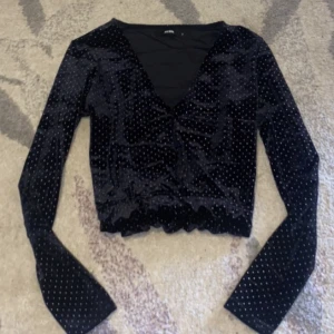 Topp från Bikbok  - Topp från Bikbok i storlek S. Ser ut som ny. På bilden ser den lite blå ut men den är svart. Har prickar som är metallpärlor.