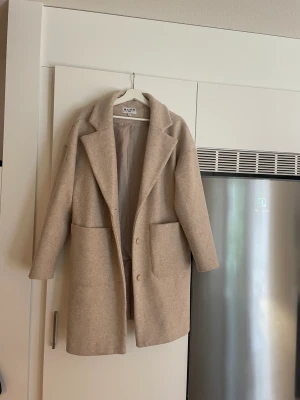 Kappa  - Beige kappa från NA-KD. Storlek 36. Oversize jacka i fint skick. 