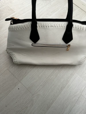 Väska  - En svart vit väska som är perfekt till alla tillfällen knappast använd. Den har bara legat i mitt rum. Den är i ett väldigt bra skick 