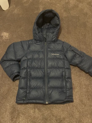 Peak performance jacka  - Säljer en varm peakperformence jacka storlek 150. Den är perfekt för vinter och att åka skidor. Den har ett litet hål på högrev armbågen med det är lagat, se på bild. Tveka inte om att ställa frågor eller att diskutera pris! 