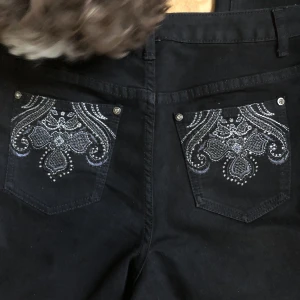 Svarta jeans med kors - Midrise/lågmidjade jeans lite baggy på. Innerben:71