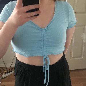 En kort magtröja, inte tajt runt magen,armarna. En vacker färg.  - En stil till dem som gillar magtröjor eller korta tröjor, som inte är förtajta eller för spända. Rekommenderar den till dig som gillar otajta magtröjor, och till dig som gillar korta tröjor. Men kan vara lite liten till dem som har lite större bröst. 