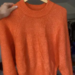 Stickad orange tröja som är jättemysig 