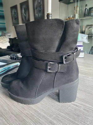 Stövlett - Ett par svarta stövletter i str 38. Endast använda en gång då mina knän inte klarade av klackarna, de är ca 7cm höga och de har en liten tjockare sula för bättre komfort. 