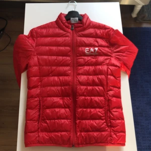 Röd Armani Jacka - En fin röd Armani jacka. Den är använd ett par gånger men det finns inga tecken på det. Inga hål eller fel på jackan. Hemmet är rök och djurfritt. Jackan köptes in för 1800 kr. 