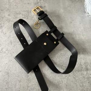 Belt in black PU leather with chain.