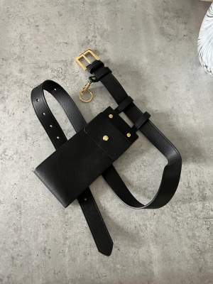 Belt in black PU leather with chain.