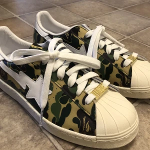 BAPE x adidas camo skor - Säljer min killes helt oanvända BAPE x adidas camo skor. Herrstorek. Anledningen är att de kom aldrig till användning så letar efter ett nytt hem till dem. 👟 Möts endast upp och i Stockholm. Enbart swish! :-) kommer utan kartong