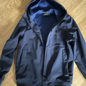 Peak Performance vårjacka - Peak performance softshell hood jacka i mörkblå i storlek M. Sparsamt använd, inga skador eller märken. Perfekt jacka att använda på våren. Nypris på deras hemsida är 2500kr för liknande modell. Mitt pris är 600kr  Mvh