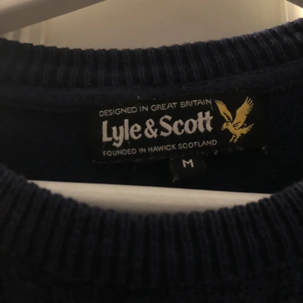 Säljer nu denna stickade Lyle & Scott tröjan i en marin blå färg som är parfekt inför vintern. Varan är i ett helt OK skick. Inga hål men defekter som en fläck förekommer. Den är i storlek M. Skriv vid fler funderingar! . Tröjor & Koftor.