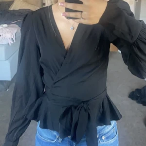 Svart Blus - Säljer denna helt oanvända svarta blus som passar perfekt till både vardag och fest. Den sitter så fint i midjan och är i jätteskönt material. Hör av dig om du har några funderingar 💞💞