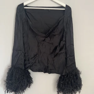 Festtopp/blus - Satintopp med glittriga ”fjädrar”. Aldrig använd, storlek 36
