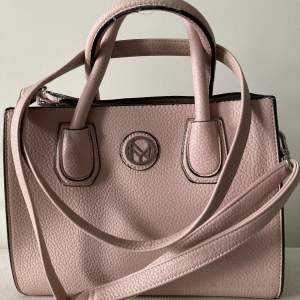 Äkta NYPD-handväska i nude rosa säljes för 1800kr. Höjd 24cm, bredd 28cm och djup 9cm. 