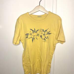 En gul somrig T-shirt med tryck av blomma på från Urban outfitters. Tröjan är i bra skick och är endast använd fåtal gånger🤍Storleken är M men skulle säga att den passar alla som är XS - M