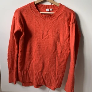 Röd stickad tröja - Går mer i korall toner men skulle ändå säga röd. Bra stretch och passar perfekt över en skjorta! 