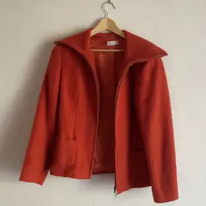 Orage-röd jacka i borstad ull säljes pga garderobsrensning. Superfin thriftad jacka jag älskat i några säsonger men inte får plats i garderoben längre. 