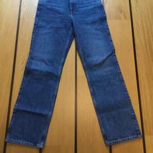 Blå jeans från Weekday W27 L 32 i modellen ”Rowe”. Hög midja och raka ben. Jeansen är helt nya och aldrig använda.