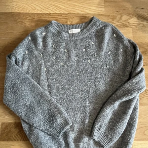 Grå stickad tröja  - Super mjuk och mysig stickad tröja med stenar. 