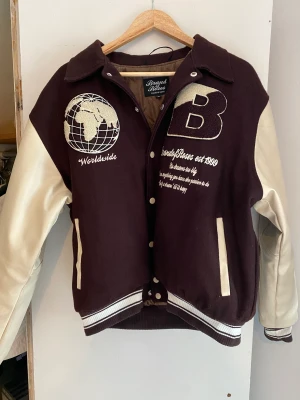 BRAND OF ROSES varisity jacket - Brand of roses varsity jacket brown, i storlek S  Köptes i somras och inte använd sen dess. Jag har haft på mig den drygt 10 gånger och den är i samma skick som en ny. Passar mig i lite oversized fit (175cm) 