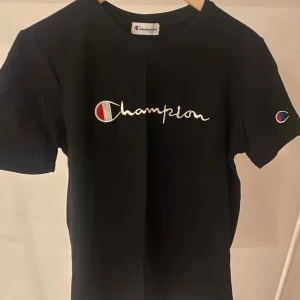 Champion t-shirt  - Svart Champion t-shirt med tryck. Skulle tro på att det är en S med den är liten i modellen. Aldrig använd, skriv för fler bilder 